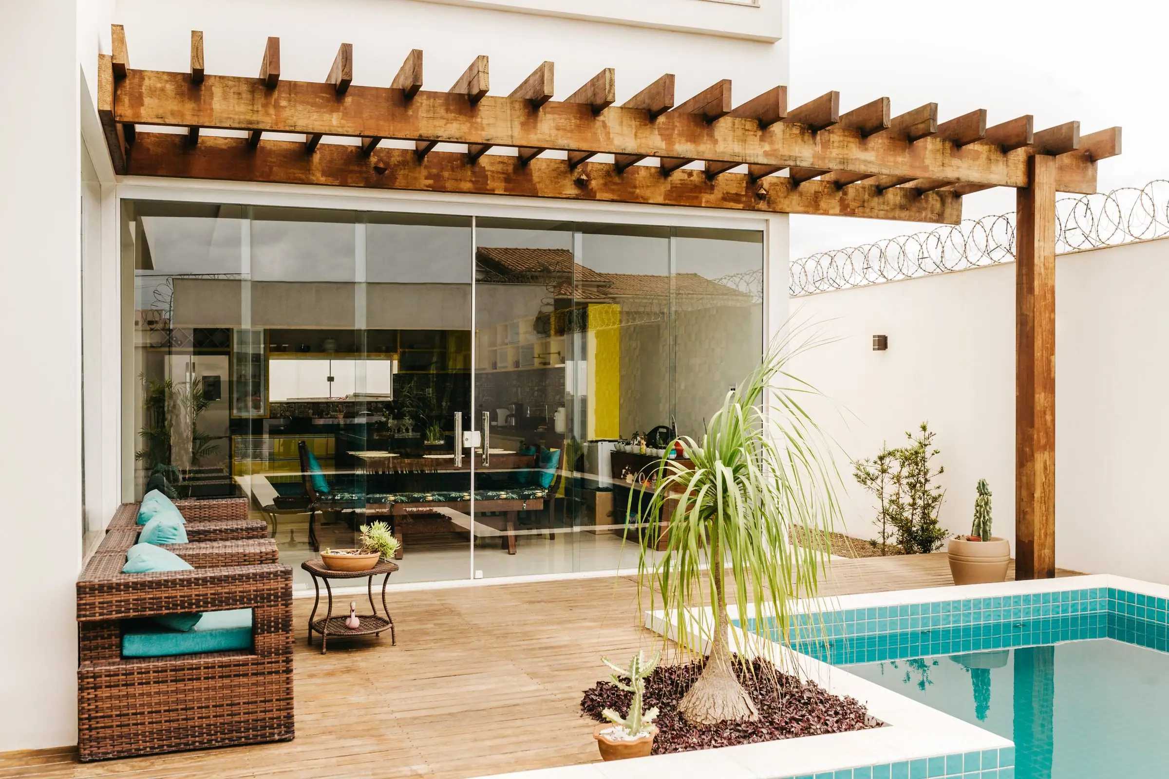 Wood pergola over a pool terrace with outdoor seating